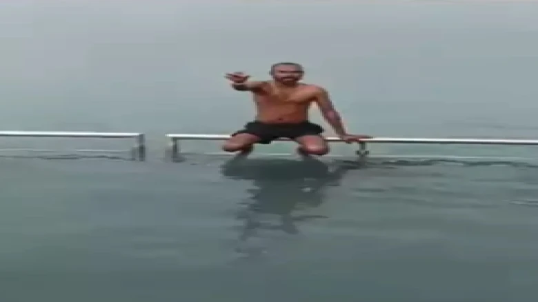 Man takes dip in freezing cold water on behalf of devotees, charges Rs 10 -Watch Video